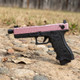 Side view of VORSK EU17 Tactical Gas Blowback Airsoft Pistol in Pink & Black on rocky ground