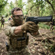 Cybergun Magnum Research Inc. Desert Eagle 50AE GBB Pistol Black aimed by masked player in woodland
