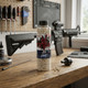Blaster Devil 0.20g 3300 Bottle Diamond Grade 6mm Airsoft BB standing on a workshop desk with a rifle in the background.