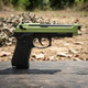 Raven R9 Replica M92 Gas Blowback Airsoft Pistol in Black & Green, side view on an outdoor wooden surface