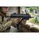 Tokyo Marui MP7A1 Compact AEP Electric Airsoft SMG held in a camouflaged player’s gloved hands at an outdoor range