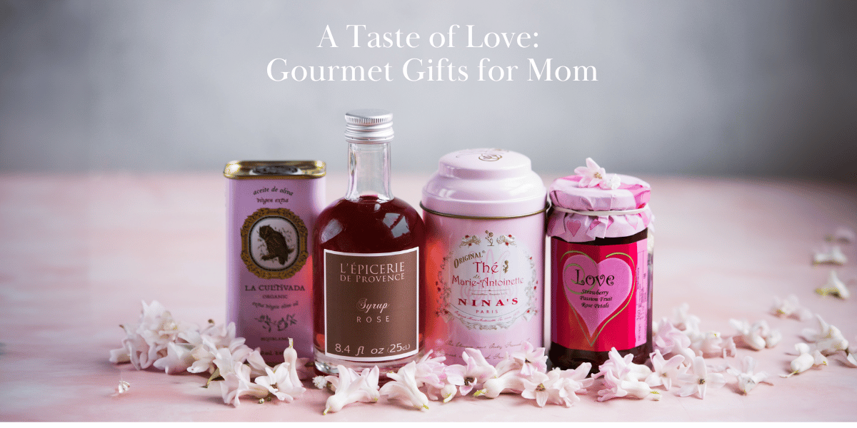  The image features a charming and elegant display of French gourmet products that would make delightful gifts for Mother's Day. In the center, it's titled "A Taste of Love: Gourmet Gifts for Mom" in a stylish, cursive font that adds a personal touch. The background is a soft, muted pink, which complements the delicate white flowers scattered around, likely hyacinths, adding a springtime feel. Prominently displayed are four products: a tin of organic olive oil, a bottle of rose syrup, a tin of 'Marie-Antoinette' tea from Nina's Paris, and a jar of 'Love' strawberry preserve. The overall composition evokes a sense of sophistication and indulgence, perfect for celebrating a day of appreciation for mothers.