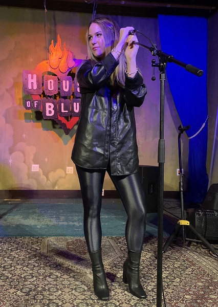 a person in leather jacket standing in front of a microphone