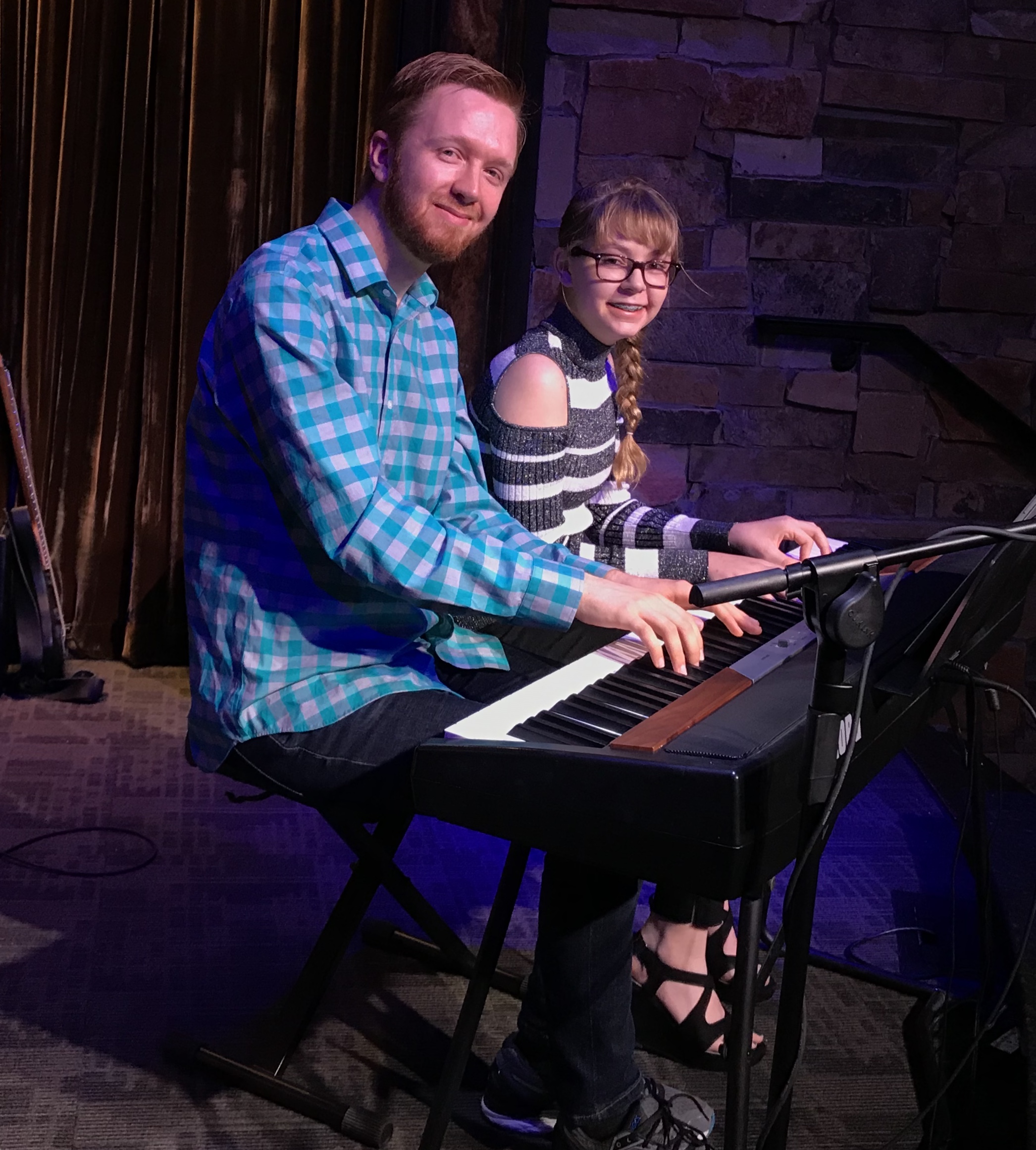 a man and a woman playing a piano