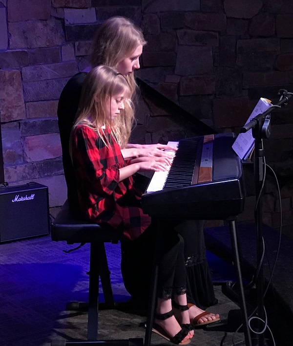 a couple of women playing piano