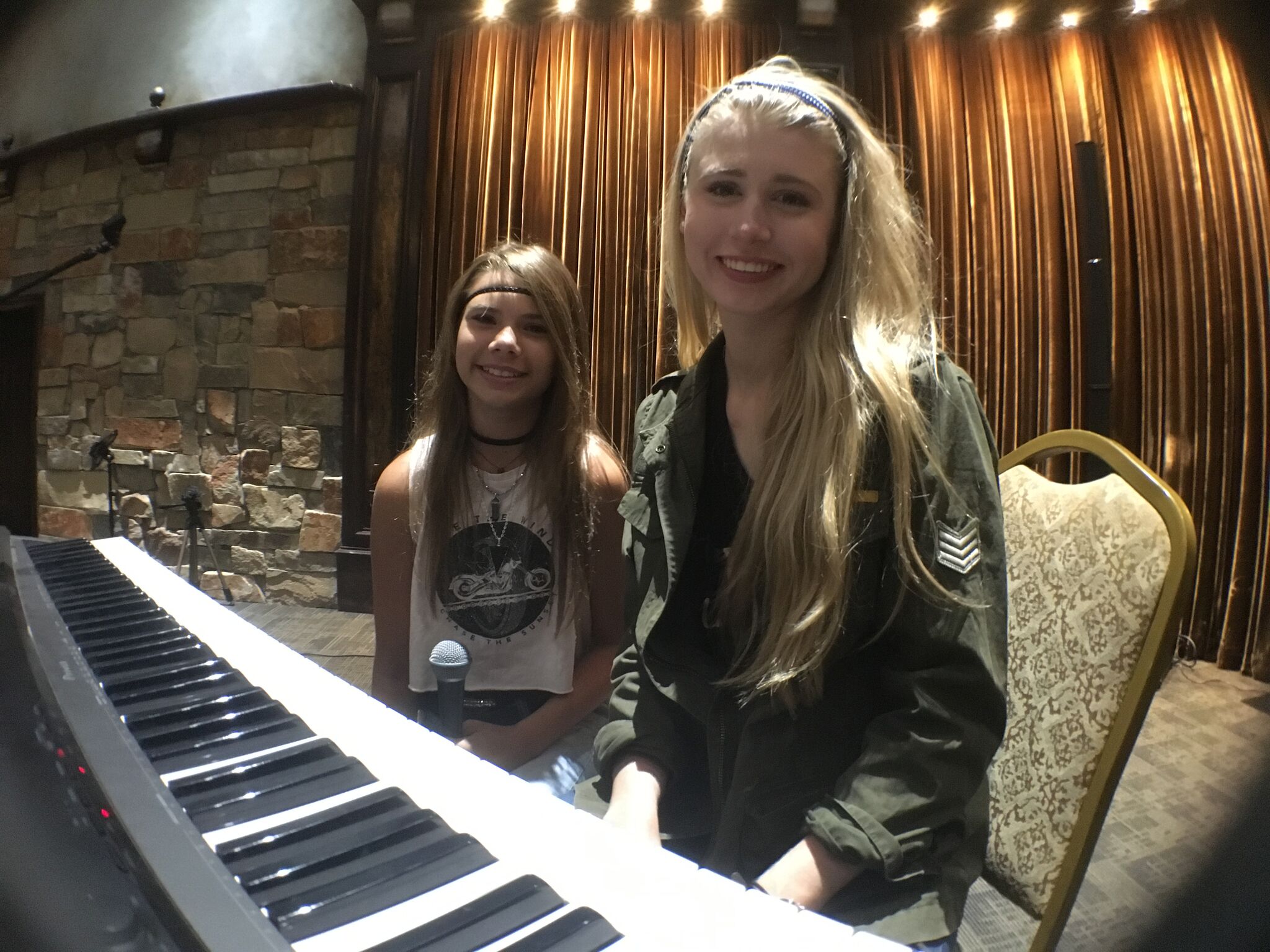 two girls sitting at a piano