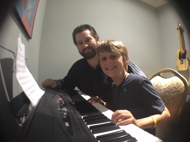 a man and a woman sitting at a piano