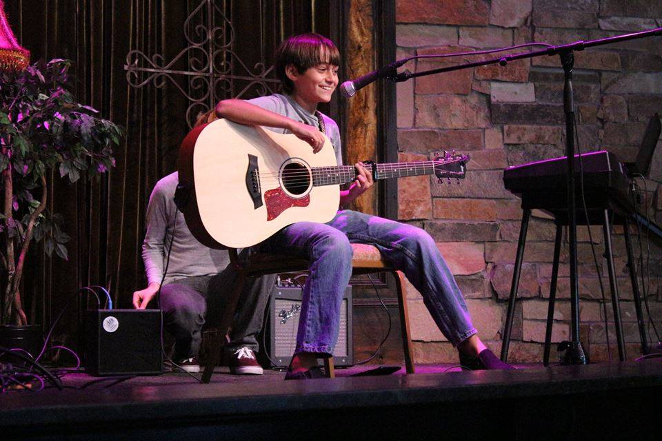 a man holding a guitar on a stage