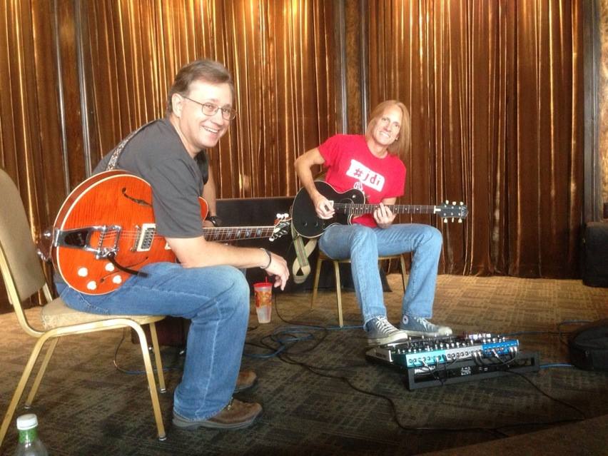 a couple of men playing guitars