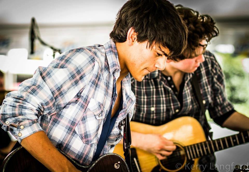 a couple of men playing guitars
