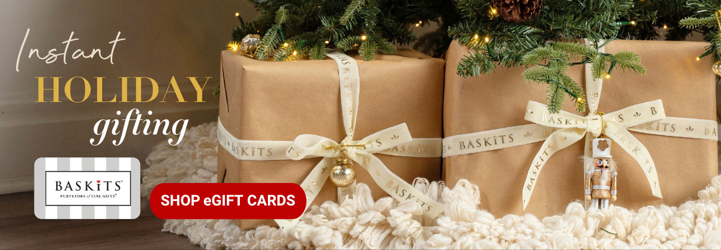 A photo of three gift baskets in front of a Christmas setting