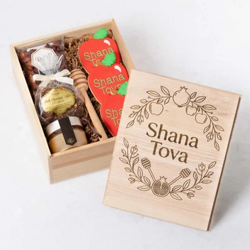 Wooden box featuring cookies, honey, honey dipper and chocolate.