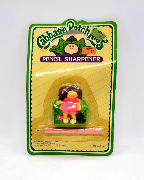 Cabbage Patch Kids 1984 Cabbage Patch Kids Pencil Sharpener, vintage doll-themed pencil sharpener with a girl figurine dressed in pink, a pink pencil, and green decoration