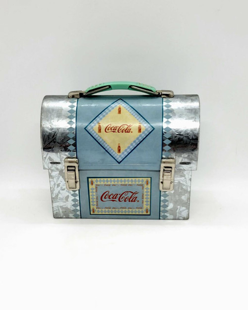 Coca-Cola Mini-Dome Lunchbox Tin, vintage Coca-Cola themed metal lunchbox with a light blue design and Coca-Cola logo, featuring a small handle on top and metal clasps on the front.