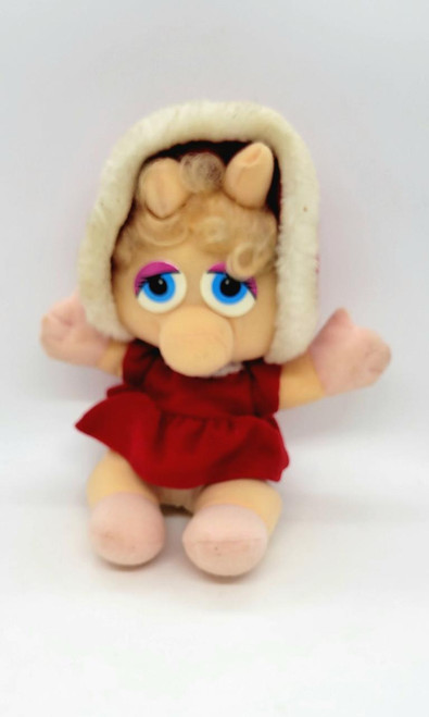 Muppet's Muppet Babies Miss Piggy Christmas Stuffed Animal, plush toy of Miss Piggy dressed in red with a cozy white hood, featuring large blue eyes and curly blonde hair.