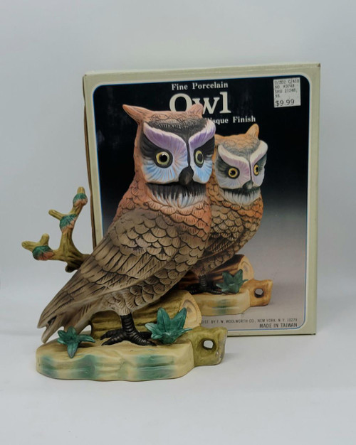 Woolworth Vintage 8-inch Fine Porcelain Owl Hand Painted Bisque Finish, detailed porcelain owl figurine with colorful facial features and textured feathers, on a decorative base with leaves, product packaging in the background.