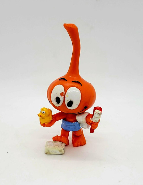 Snorks 1985 Dimmy Bath Time PVC Toy Figure, a vintage orange plastic figure depicting a character with large eyes, holding a yellow duck and a red and white ice cream bar, wearing blue shorts, on a plain white background.