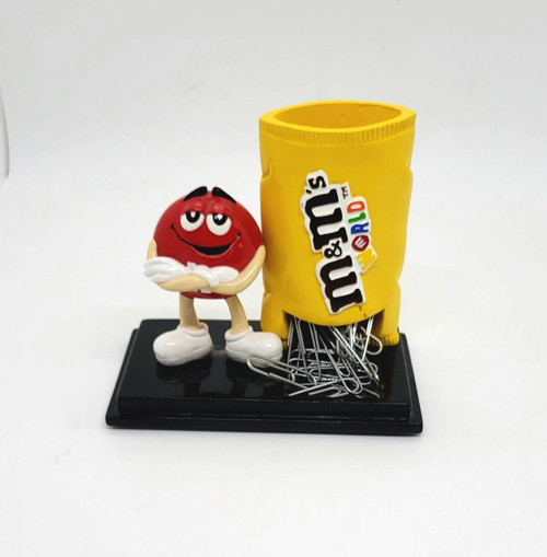 M&M's World Red M&M Desktop Paperclip Dispenser, red M&M character holding paperclips beside a yellow M&M themed container on a black display base.