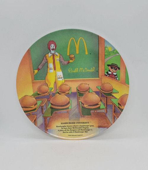 McDonald's 1989 Hamburger University Melamine Plate, vintage illustrated plate featuring Ronald McDonald and Happy Meal mascots with hamburgers, classroom setting, and McDonald's logo.