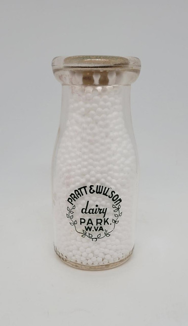 Pratt & Wilson Dairy Vintage Pratt & Wilson Dairy Park West Virginia Half Pint Milk Bottle, clear glass milk bottle filled with white milk particles and featuring a vintage logo.