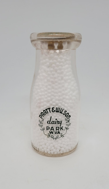 Vintage Pratt & Wilson dairy from Park, West Virginia half pint milk bottle.  The back side says "try our delicious cottage cheese" in green. The bottle stands a little over 5-inches tall and 2.5-inches wide.