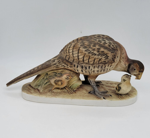 Female Ring-necked pheasant figurine that features her with her chicks.  She is preparing to feed one while the other is hiding under her. The figurine is by Andrea by Sadek.  