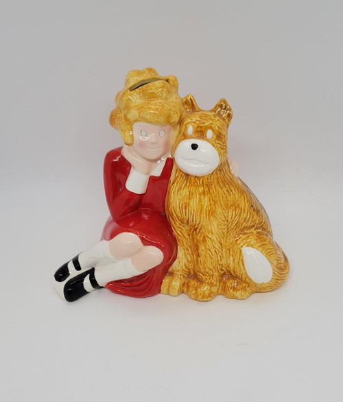 Applause Annie and Sandy Ceramic Bank, a colorful ceramic piggy bank featuring a girl in a red dress and a large brown dog sitting side by side.