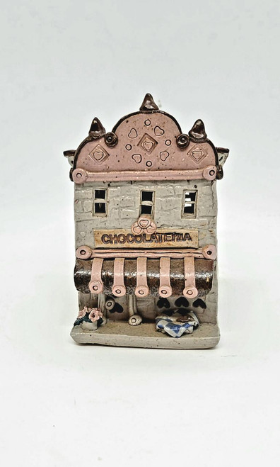 Windy Meadows Pottery Chocolateria Clay House, decorative miniature ceramic building with pink and gray colors, featuring a sign that says 'Chocolatezia,' small windows, and a striped awning.