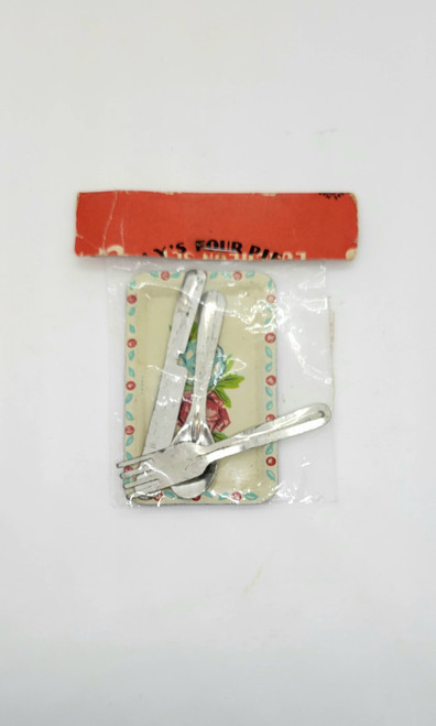 Vintage toy aluminum tray with utensils that can be used for dolls or scene setting.  The tray is 3.25" long and 2" wide with red and blue flower on it.  The utensils include a fork, spoon and knife as a place setting.  They measure 3" long.