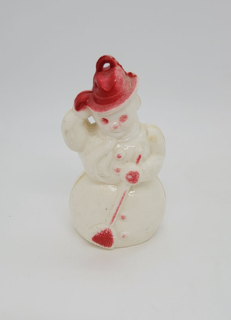 Vintage plastic snowman Christmas ornament that features a snowman wearing red hat and buttons while holding a red broom.  The ornament hangs from the loop on the hat.