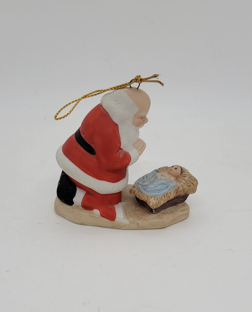 Vintage 1985 The Kneeling Santa ceramic ornament by Roman Inc.  The ornament features Santa Claus kneeling over baby Jesus with his hat off.