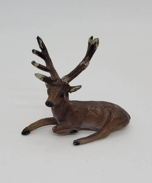 Unknown Vintage Miniature Metal Deer Figure, small brown deer with black antlers and glossy black hooves, lying on a plain white background.