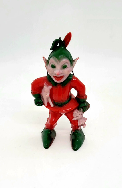 Vintage Rosbro hard plastic elf Christmas ornament.  The elf stands 3.25 inches tall with his feather in his cap.  The elf is wearing a red outfit with green shoes, gloves, belt, collar and hat.  The elf is holding gifts in his hands.