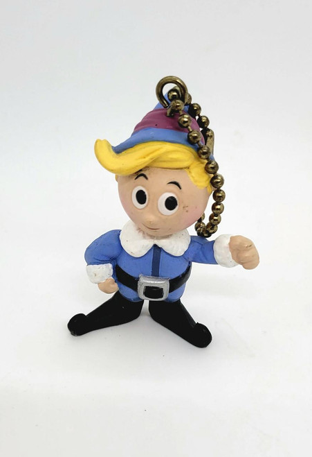 Memory Lane Rudolph the Red Nosed Reindeer Hermey Key Chain, cartoon-like figurine of Hermey with blonde hair, dressed as an elf, wearing a pink and blue hat, blue outfit with white collar and black belt, standing with hands on hips.