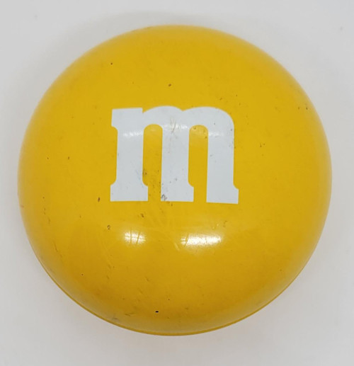 Yellow M&M's 3-inch tin, snack container featuring the white M&M character logo on a yellow background.
