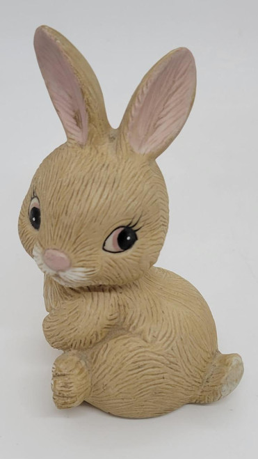 HOMCO Seated Bunny Ceramic Figurine, a cute beige rabbit figurine with detailed fur texture, large pink and black eyes, and pink inner ears, sitting with paws crossed.