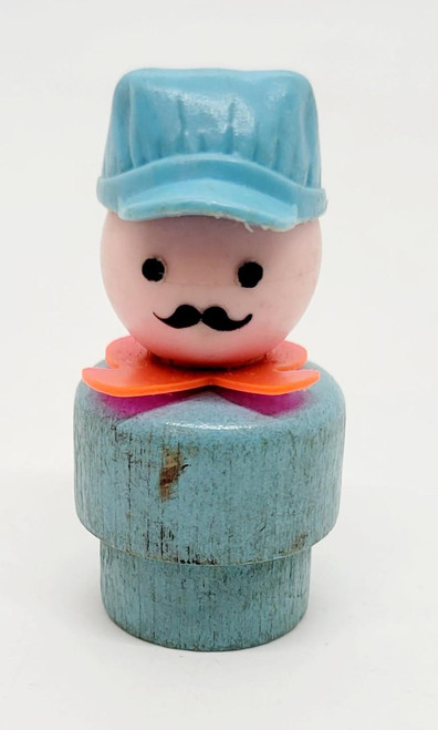 Fisher-Price Fisher Price Original Little People Caucasian Train Engineer - Wood Body, toy figure with a pink face, black eyes, black mustache, blue cap, and orange detail, standing on a round blue wooden base.