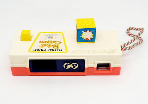 Fisher-Price 1974 Pocket Camera 464 - A Trip To The Zoo, vintage toy camera with a colorful design, red, white, yellow, and blue colors, featuring a small yellow square and a multicolored cube on top, and a red-and-white braided strap.