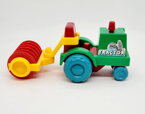 Playmates 1985 Li'l Playmates Farm Play Set - Tractor with Disc Plow, colorful toy tractor with a red disc plow attachment, green and blue plastic construction, designed for children's farm play activities.