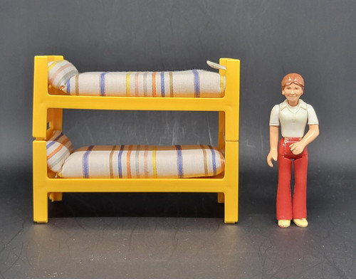 Fisher-Price Doll House Decorator Set #259 Bunk Beds, plastic bunk beds with striped fabric mattresses and a smiling female figurine with brown hair in casual clothes.