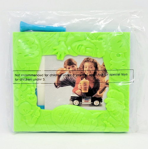 Wendy's Kids' Meal Toy 1995 Make Room - Picture Frame, green plastic frame with embossed cartoon character designs surrounding a photo of children, plastic blue tool included in packaging.