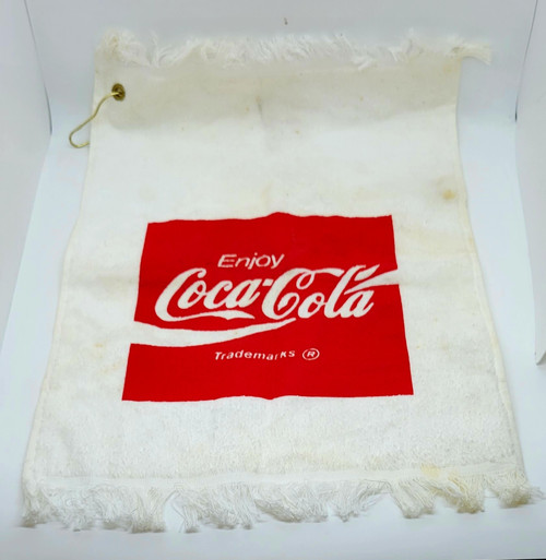 Coca-Cola Golf Towel, white towel with red Coca-Cola logo and the word 'Enjoy' printed on it.