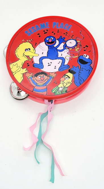 Sesame Street Vintage Kids Sesame Place / Sesame Street Red / Pink Tambourine Souvenir, colorful children's tambourine featuring Sesame Street characters like Big Bird, Grover, and Cookie Monster with streamers.