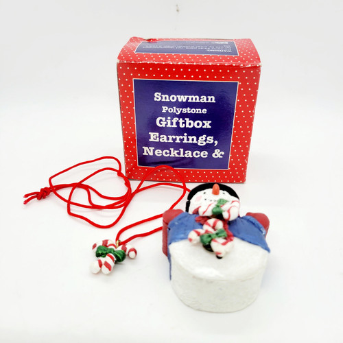 Snowman Polystone Giftbox Candy Cane Earrings and Necklace, festive holiday jewelry set with a snowman ornament and red string accessories in front of a red and blue box.