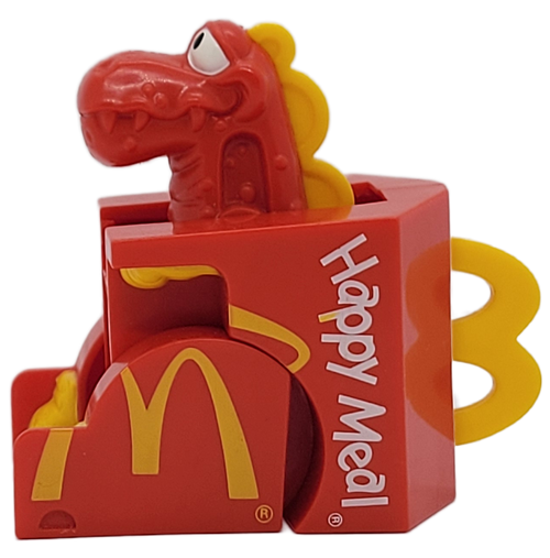 McDonald's Happy Meal toy of Happy Meal-O-Don from the 1990 McDino Changeables series.  The Happy Meal-O-Don looks like a Happy Meal box and transforms into a dinosaur. The series contains 10 different McDonald's foods that transform into dinosaurs. The series was available May 24 - June 20, 1991.
