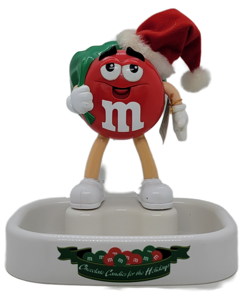 M&M's talking animated Christmas candy dish featuring the Red M&M with green sack and a red Santa hat.  The candy dish has on/off switch on the back of the sack and stands 9-inches tall.