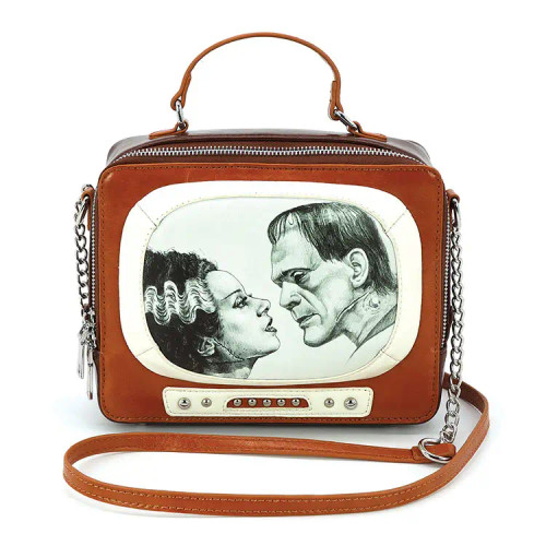 Uniquely Designed Frankenstein and Bride vintage TV set bag in vinyl. Channel vintage horror with a fashion twist—this Frankenstein and Bride Vintage TV Crossbody is a standout piece for shops looking to stock something bold, nostalgic, and just a little spooky. With its retro television shape and vivid monster couple print, this bag offers a strong visual hook that appeals to collectors, Halloween enthusiasts, and lovers of quirky statement accessories.