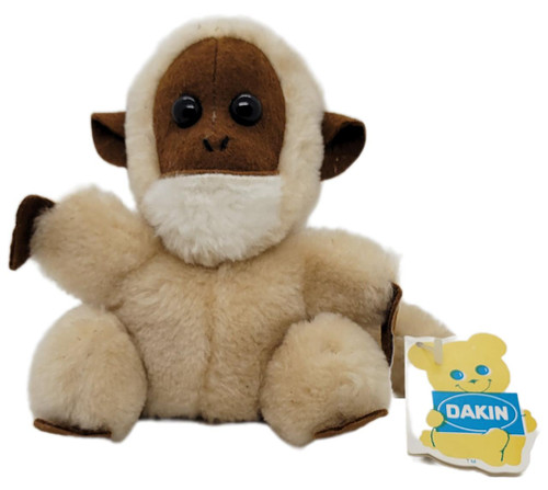 Dakin Bean Bags 1976 Magpie Monkey Plush With Tag, a soft plush toy monkey with a cream fleece body, brown face, and ears, wearing a white fluffy mask, with a Dakin brand tag attached.