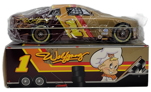 Wolfgang Candy motorsports tin.  Wolfgang Candy is from York, PA that started in 1921.  The motorsports tin looks like a race car with gold, red, yellow and brown color scheme.  The hood has Wolfgang Candy chocolatier holding a checkered flag.