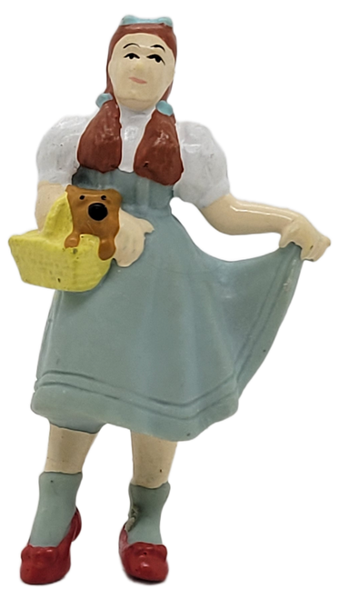 The Wizard of Oz 1989 figure of Dorthy Gale by Applause.  The 2.5-inch tall PVC figure features Dorthy wearing her blue dress with white top and ruby red slippers while carrying Toto in her yellow basket. The Wizard of Oz 1989 figure of Dorthy Gale by Applause.  The 2.5-inch tall PVC figure features Dorthy wearing her blue dress with white top and ruby red slippers while carrying Toto in her yellow basket.